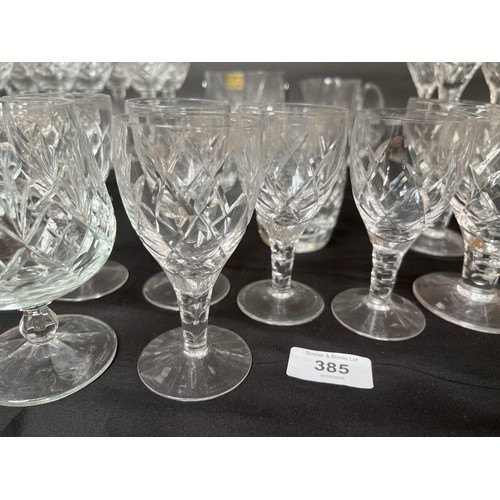 385 - A quantity of cut crystal wine glasses, whisky glasses, facet cut decanter and matching glasses.