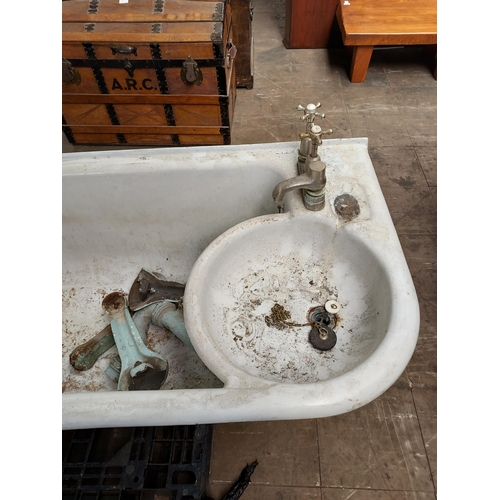 299 - Antique cast metal and enamel bath tub with fitted taps , comes with pedestal legs.