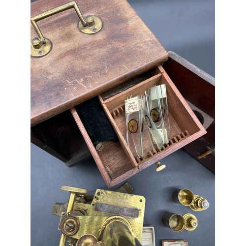 144 - Antique brass table top microscope, comes with various lenses, slides, and original carry box.