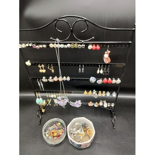 33 - Quantity of earrings on stand together with badges etc.