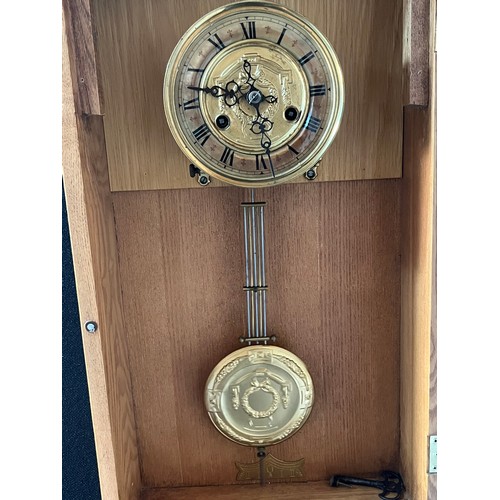 588 - Light oak cased wall clock, Ornate brass style face and matching pendulum. Comes with key. [Will not... 