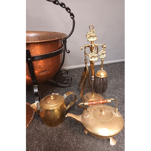 800 - Copper pot in a metal swing handle surround with fire brasses, together with a copper plaque, the cr... 