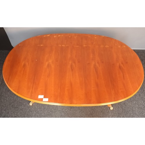 821 - Reproduction table, the oval top raised on two turned columns and three outswept legs ending in bras... 