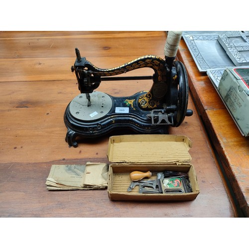 285 - An antique hand Cranked sewing machine by Jones with original leaflet and accessories .