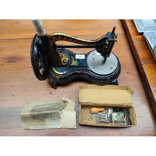 285 - An antique hand Cranked sewing machine by Jones with original leaflet and accessories .