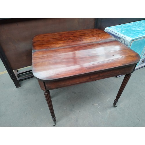 254 - Antique mahogany folding games table, supported on turned legs and castor feet.