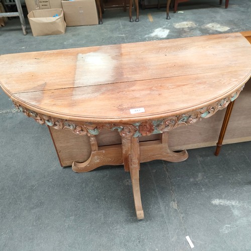 447 - Ornate carved heavy wood half moon table .