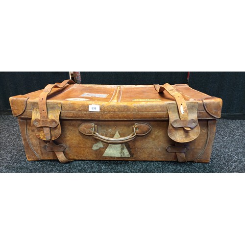 858 - Antique tan leather travel case. Fitted with straps and has original travel stickers showing.