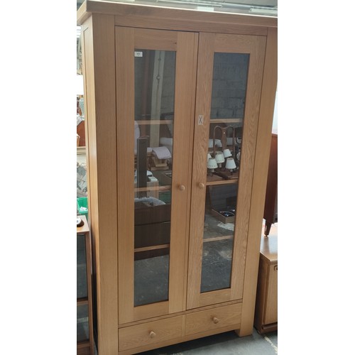 455 - Large light oak two door display cabinet.