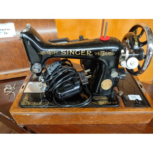 180 - Singer sewing machine in fitted wooden case with key .