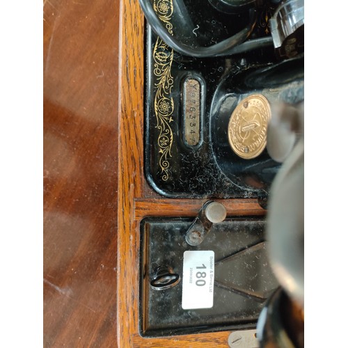 180 - Singer sewing machine in fitted wooden case with key .