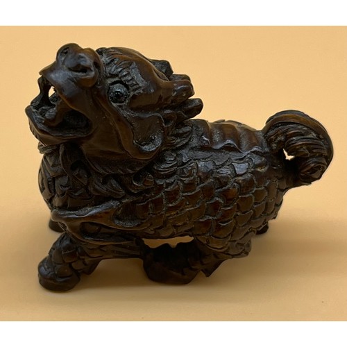 551 - Antique Japanese hand carved netsuke of a foo dog. Signed to base. [4.5cm in length]