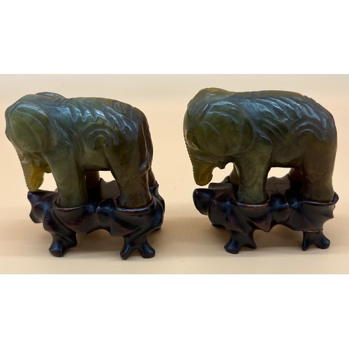 561 - Two Chinese hand carved elephant sculptures sat upon wooden carved stands. [8cm high]