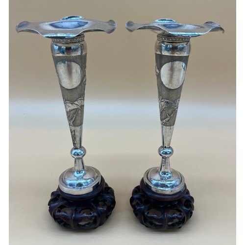 563 - A Pair of Chinese Export silver bud vases sat upon carved wooden stands. [20cm high] Maker's mark to... 