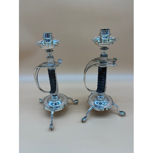 568 - A Pair of VR Stamped British army sword handle candlesticks. Supported by spurs. [30.5cm high]