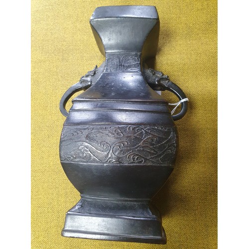 554 - Antique Chinese Bronze vase with Demon shaped handles and showing three bands with various designs. ... 