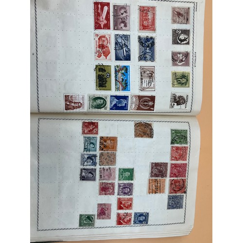 63 - The Triumph stamp album containing a large quantity of stamps from around the world. [Will post]