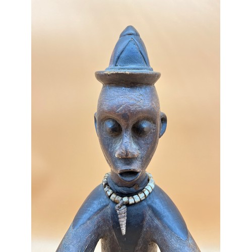 551 - Antique African Nigerian hand carved wooden tribal seated figure, decorated with cone shaped hat, sh... 