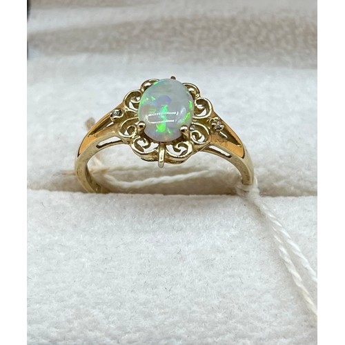 14A - 9ct yellow gold ladies ring set with a single opal stone off set by two small diamonds. [1.93grams] ... 