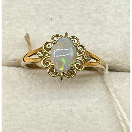 14A - 9ct yellow gold ladies ring set with a single opal stone off set by two small diamonds. [1.93grams] ... 