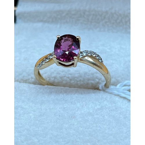 19A - 10ct yellow gold ladies ring set with a single pink tourmaline stone off set by white spinel stones.... 