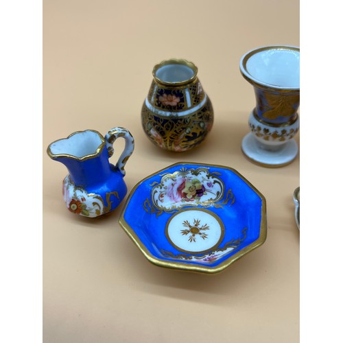 23A - Collection of collectable miniature porcelain items to include Dolls tea for two service, Urn vases,... 