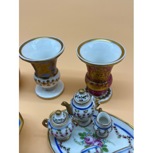 23A - Collection of collectable miniature porcelain items to include Dolls tea for two service, Urn vases,... 