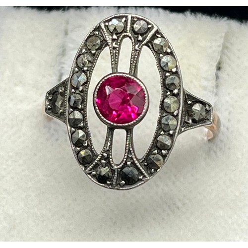 15 - Gold and silver art deco ring set with a single round cut ruby surrounded by marcasite stones. [Ring... 