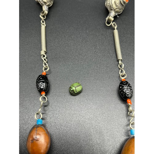 25 - Middle East white metal and bead necklace, together with a carved scarab beetle sculpture. [0.9cm]