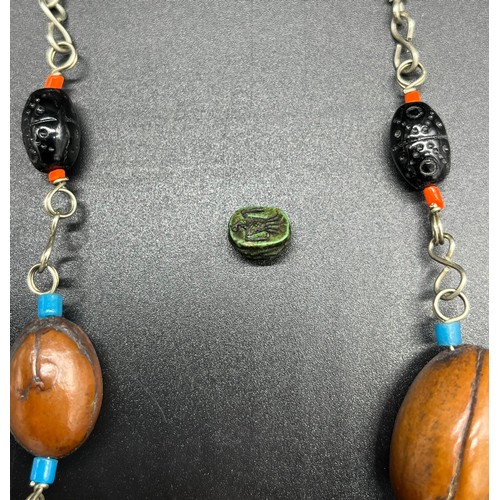 25 - Middle East white metal and bead necklace, together with a carved scarab beetle sculpture. [0.9cm]