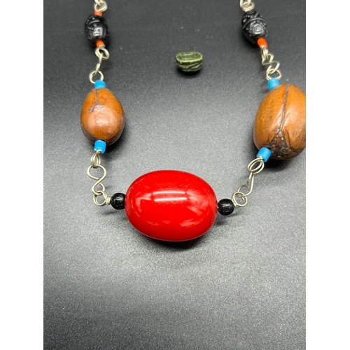 25 - Middle East white metal and bead necklace, together with a carved scarab beetle sculpture. [0.9cm]