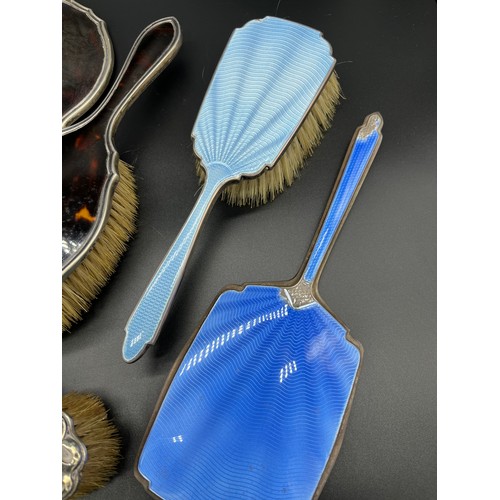 28 - Three-piece silver and tortoise shell dressing table brushes and hand mirror, Two silver and blue en... 