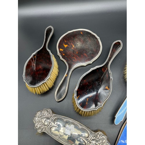 28 - Three-piece silver and tortoise shell dressing table brushes and hand mirror, Two silver and blue en... 