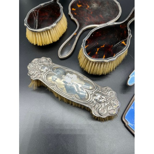 28 - Three-piece silver and tortoise shell dressing table brushes and hand mirror, Two silver and blue en... 