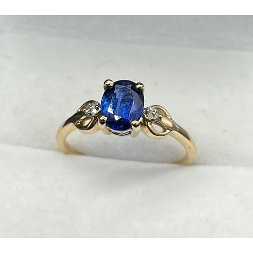 38 - 10ct yellow gold ring set with a single blue spinel stone off set by diamonds. [Three diamonds to ea... 