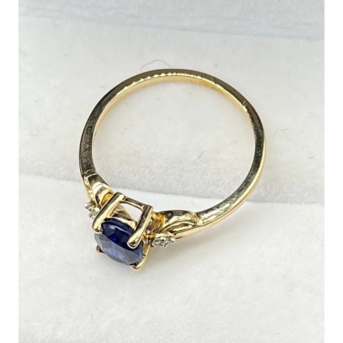 38 - 10ct yellow gold ring set with a single blue spinel stone off set by diamonds. [Three diamonds to ea... 