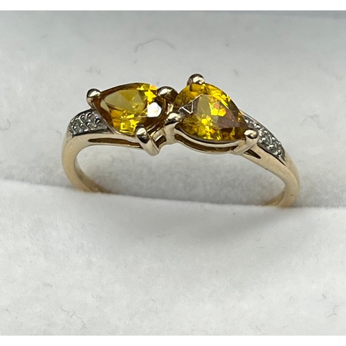 39 - 10ct yellow gold ring set with two tear drop cut yellow tourmalines off set by diamonds to each shou... 