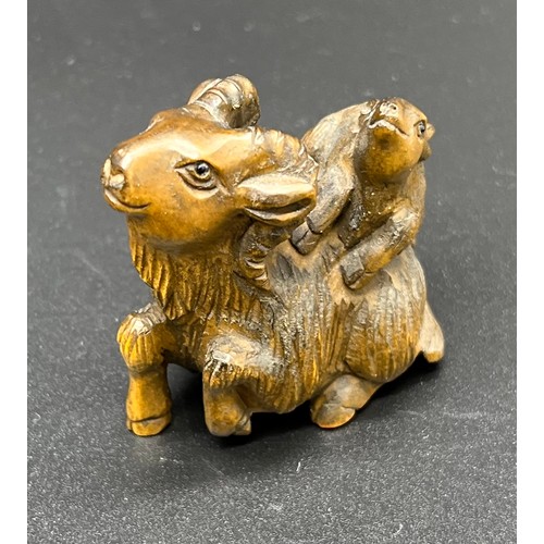 51 - Hand carved Japanese Netsuke sculpture of a Mother Ram and baby on back. Signed. [4.5cm high]