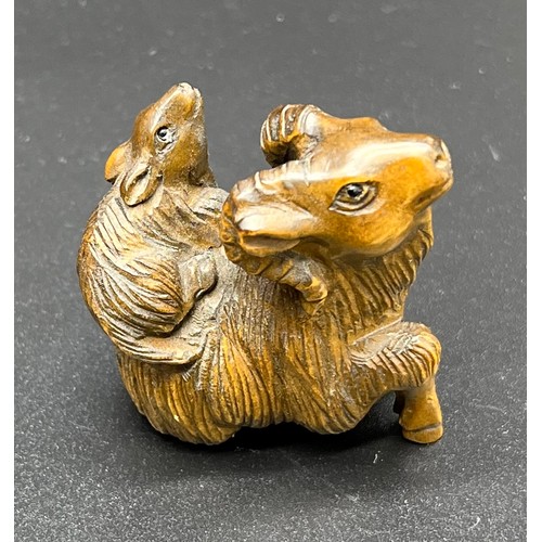 51 - Hand carved Japanese Netsuke sculpture of a Mother Ram and baby on back. Signed. [4.5cm high]