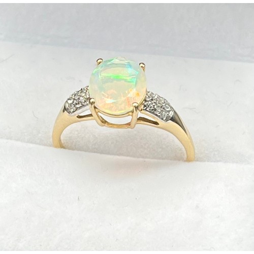 53 - 10ct yellow gold ladies ring set with an oval cut opalescent style centre stone off set by white spi... 