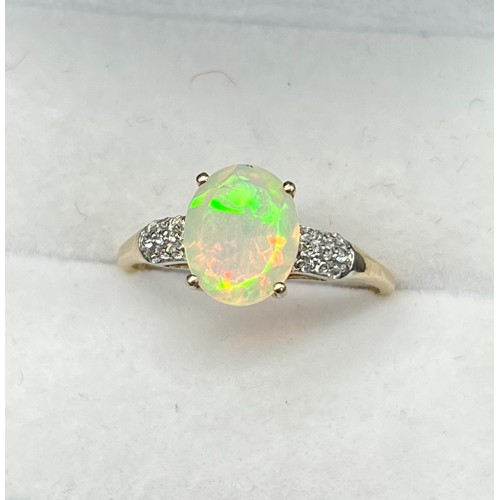 53 - 10ct yellow gold ladies ring set with an oval cut opalescent style centre stone off set by white spi... 