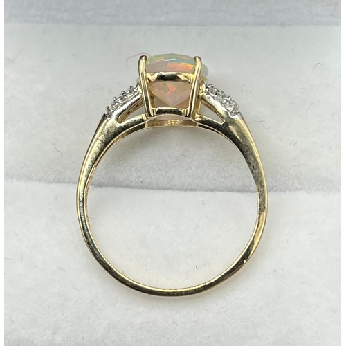 53 - 10ct yellow gold ladies ring set with an oval cut opalescent style centre stone off set by white spi... 