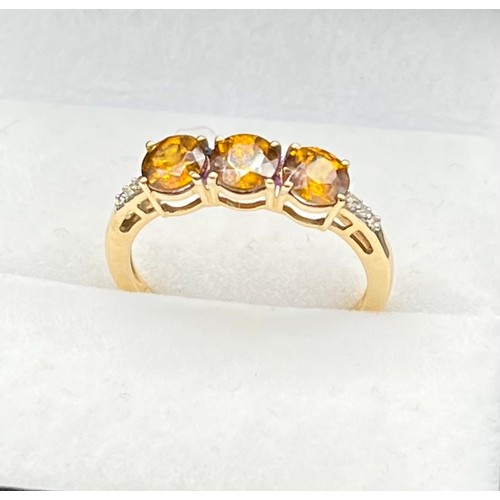 54 - 10ct yellow gold ladies ring set with three round cut orange tanzanite stones off set with diamond s... 