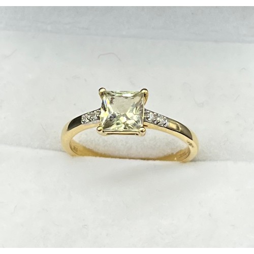 58 - 10ct yellow gold ladies ring set with a princess cut pale green topaz off set by diamond stone shoul... 