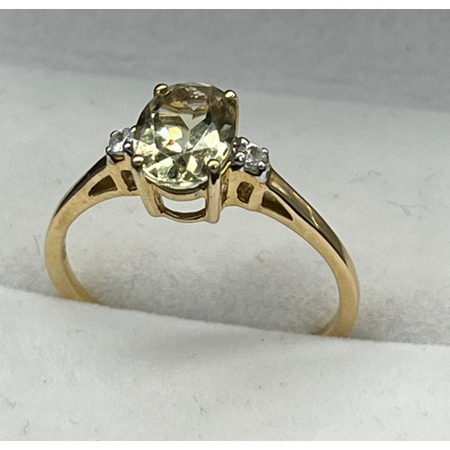 60 - 10ct yellow gold ladies ring set with a single oval cut pale green spinel stone off set by white spi... 