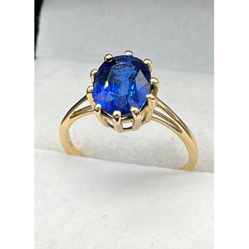 64 - 10ct yellow gold ring set with a large oval cut blue topaz stone. [Ring size P] [2.60Grams]