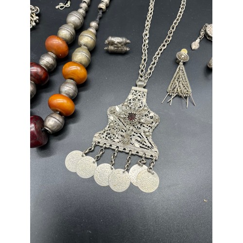 84 - Collection of Middel east jewellery to include amber and white metal necklace, White metal filigree ... 