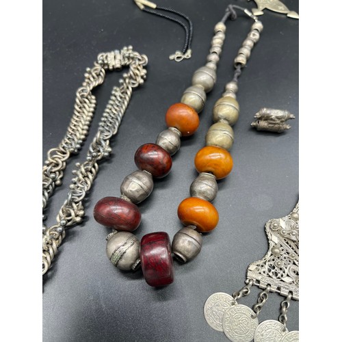 84 - Collection of Middel east jewellery to include amber and white metal necklace, White metal filigree ... 