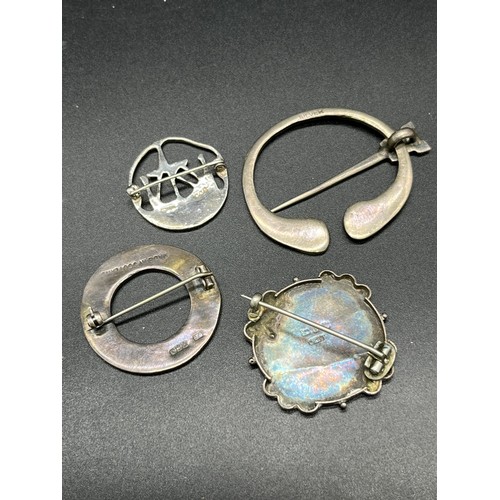 88 - Four various silver brooches. Includes Celtic plaid brooch, Edinburgh silver long boat brooch by Ton... 