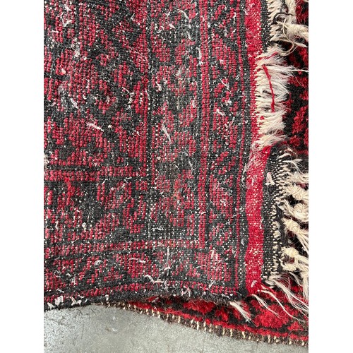 161 - Antique hand woven Indian/ Persian red and black ground rug. [193x120cm]